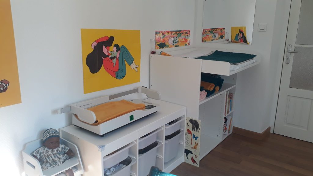 Espace intérieur lumineux et accueillant de GraineSante dédié à la petite enfance avec des meubles blancs, des jouets colorés et une zone de soin pour bébé dans les Pyrénées-Orientales.